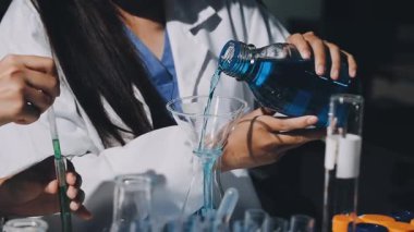 Kadın doktor laboratuarda matara tutuyor.