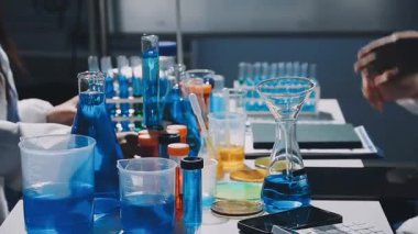 Koruyucu gözlüklü ve eldivenli bilim adamı laboratuarda çalışıyor.