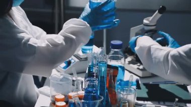 Cam matara tutan koruyucu eldivenli bilim adamı.