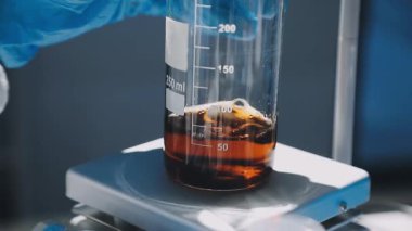 Ellerindeki kimyasal şişenin yakın plan görüntüsü. Laboratuvar içinde kimyasal tüp olan bir sıvıyla dolu..