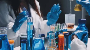 Bilim adamının şişeyle cam tutarken yakın plan fotoğrafı.