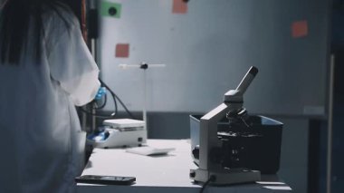 Laboratuvarda çalışan üniformalı kadın bilim adamı.