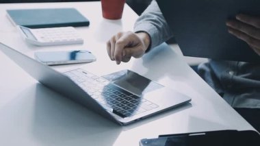 İşadamı tablet üzerinde çalışıyor ve ofiste otururken elinde kalem tutuyor..