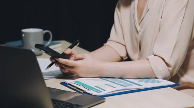 Genç bayan girişimci ofiste bir bilgisayar üzerinde çalışıyor.