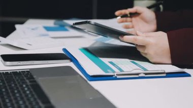 İşadamı masadaki dizüstü bilgisayarını ve akıllı telefonunu kullanıyor..