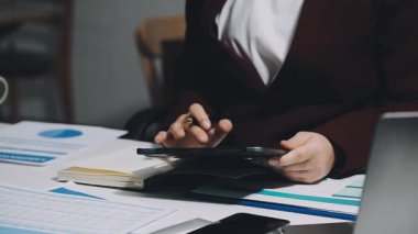 Yakın plan - Bilgisayarda çalışan ve ofisteki mali tabloları analiz eden iş adamı
