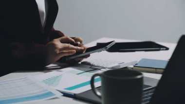 Dizüstü bilgisayar ve belgelerle çalışan bir iş adamı