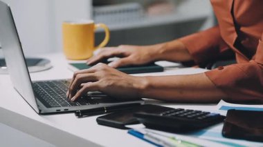 Dizüstü bilgisayarda çalışan bir kadının yakın görüntüsü.