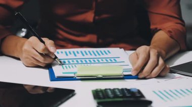 İş adamı elinde kalem ve hesap makinesi tutuyor.