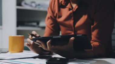 Akıllı telefon kullanan ve notlar yazan bir iş adamı.