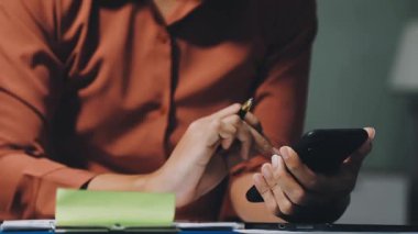 Ofisteki akıllı telefon ve hesap makinesini kullanarak iş kadını elini kapat. finans kavramı.