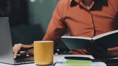 Genç adam kafede kitap okuyor.