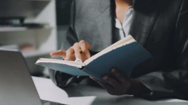 İş adamı işyerinde kitap okuyor.