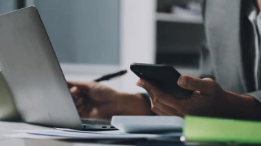 Ofisteki masada dizüstü bilgisayar ve cep telefonu kullanan bir iş adamı. iş ve teknoloji kavramı.