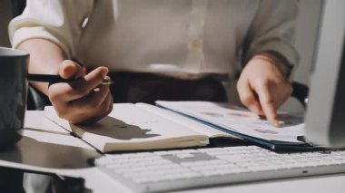 Ofiste çalışan genç bir iş kadını, masada oturuyor.