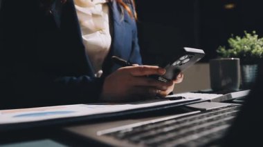 Ofiste dizüstü bilgisayar kullanan akıllı telefonlu bir iş kadını. Dijital tablet bilgisayar kullanan bir kadın. teknoloji ve dijital çalışma.