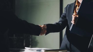Ofiste iki işadamı el sıkışıyor.