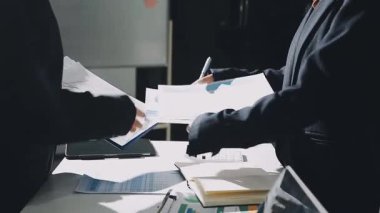 İşadamları, bürodaki belgelerle bir sözleşmeyi tartışıyor.
