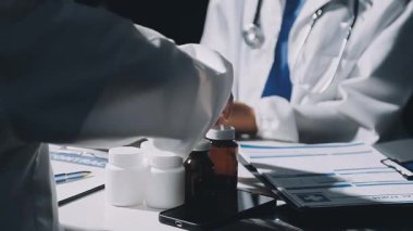 Doktor elinde haplarla tablet tutuyor..