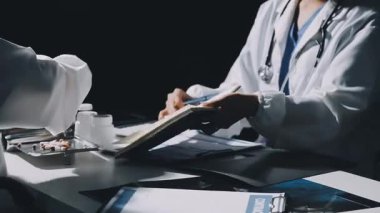 Doktor notlar yazıyor ve masada hasta var.