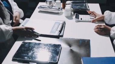 Doktorun elinde bir tablet tutarken ve klinikteki masanın üzerine yazı yazarken. tıbbi teknoloji, tıp, sağlık hizmeti kavramı.