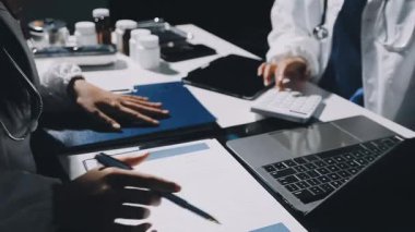 Doktor masada otururken panoya yazı yazıyor.