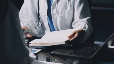 Tıp üniformalı doktor, modern hastanedeki raporu üzerinde çalışırken dizüstü bilgisayar kullanıyor. Sağlık hizmetleri ve sağlık sigortası kavramı.