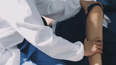 Siyah takım elbiseli, dövmeli ve mavi gökyüzünün arka planında beyaz gömlekli genç bir adam.