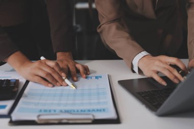 Muhasebe şirketi kazançlı nakit akışı için finansman ve vergilendirme planlaması, ofiste çalışan denetçi ve muhasebeci ekibi, mali verileri ve muhasebe kayıtlarını hesap makinesiyle analiz eder.