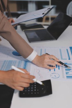 Muhasebe şirketi kazançlı nakit akışı için finansman ve vergilendirme planlaması, ofiste çalışan denetçi ve muhasebeci ekibi, mali verileri ve muhasebe kayıtlarını hesap makinesiyle analiz eder.