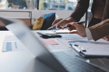Muhasebe şirketi kazançlı nakit akışı için finansman ve vergilendirme planlaması, ofiste çalışan denetçi ve muhasebeci ekibi, mali verileri ve muhasebe kayıtlarını hesap makinesiyle analiz eder.