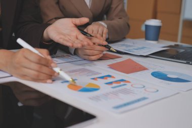 Muhasebe şirketi kazançlı nakit akışı için finansman ve vergilendirme planlaması, ofiste çalışan denetçi ve muhasebeci ekibi, mali verileri ve muhasebe kayıtlarını hesap makinesiyle analiz eder.