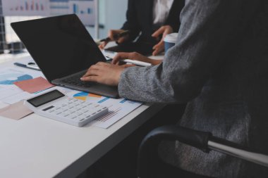 Muhasebe şirketi kazançlı nakit akışı için finansman ve vergilendirme planlaması, ofiste çalışan denetçi ve muhasebeci ekibi, mali verileri ve muhasebe kayıtlarını hesap makinesiyle analiz eder.