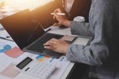 Muhasebe şirketi kazançlı nakit akışı için finansman ve vergilendirme planlaması, ofiste çalışan denetçi ve muhasebeci ekibi, mali verileri ve muhasebe kayıtlarını hesap makinesiyle analiz eder.