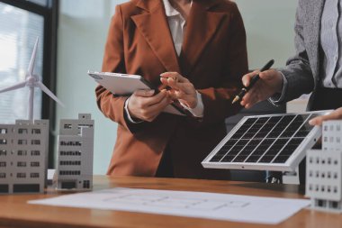 İş adamları arasında güneş pili paneli teknolojisi ve Güneş Enerjisi Çevre Kenti kavramındaki son gelişmeler üzerine tartışma.