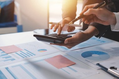 Muhasebe şirketi kazançlı nakit akışı için finansman ve vergilendirme planlaması, ofiste çalışan denetçi ve muhasebeci ekibi, mali verileri ve muhasebe kayıtlarını hesap makinesiyle analiz eder.