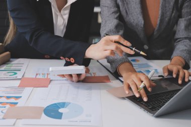 Muhasebe şirketi kazançlı nakit akışı için finansman ve vergilendirme planlaması, ofiste çalışan denetçi ve muhasebeci ekibi, mali verileri ve muhasebe kayıtlarını hesap makinesiyle analiz eder.