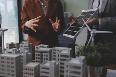 İş adamları arasında güneş pili paneli teknolojisi ve Güneş Enerjisi Çevre Kenti kavramındaki son gelişmeler üzerine tartışma.