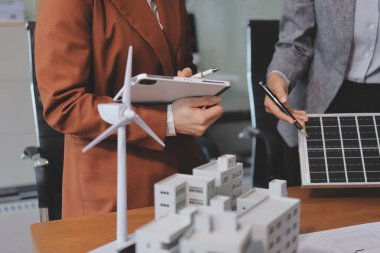 İş adamları arasında güneş pili paneli teknolojisi ve Güneş Enerjisi Çevre Kenti kavramındaki son gelişmeler üzerine tartışma.