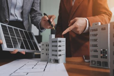 İş adamları arasında güneş pili paneli teknolojisi ve Güneş Enerjisi Çevre Kenti kavramındaki son gelişmeler üzerine tartışma.