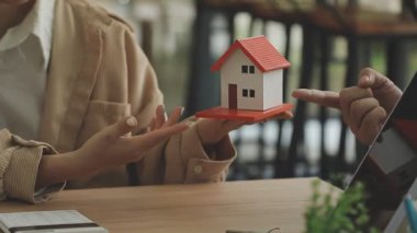 Arka planda anahtarları ve evi olan genç bir çift.