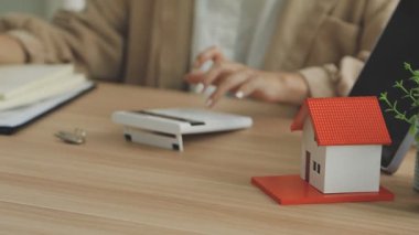Emlakçı ev modelini dizüstü bilgisayarla tutuyor. Emlakçı konsepti