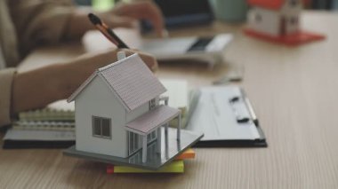 Minyatür model: Adam dizüstü bilgisayar, ev ve hesap makinesi üzerinde çalışıyor. konsept işi, sigorta, mülk, gayrimenkul, kredi.