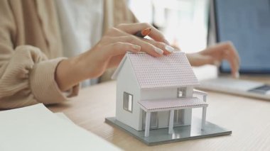 Masasında dizüstü bilgisayarı olan ev modeli, emlakçı konsepti..