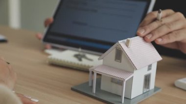 Emlakçı müşteriye evin anahtarını gösteriyor. ev sigortası kavramı