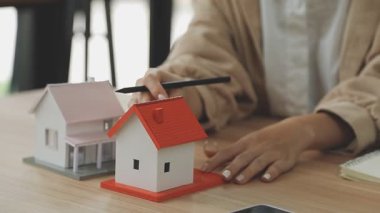 Emlakçı ev modelini ev alıp almak için gösteriyor.