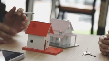 Elinde model ve anahtar olan bir ajan ya da ev. mortgage veya kredi kavramı.