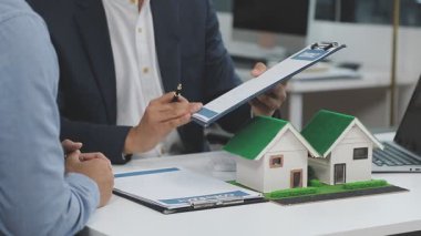 Emlakçı evin anahtarlarını model üzerinde gösteriyor, yakın plan..