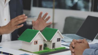 Emlakçı müşteriye ev modeli veriyor.