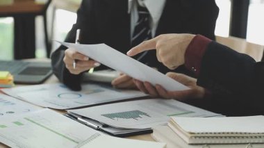 İşadamları ve işadamları bir dizüstü bilgisayar üzerinde çalışıyorlar ve ofiste yeni bir mali planın sonuçlarını tartışıyorlar.